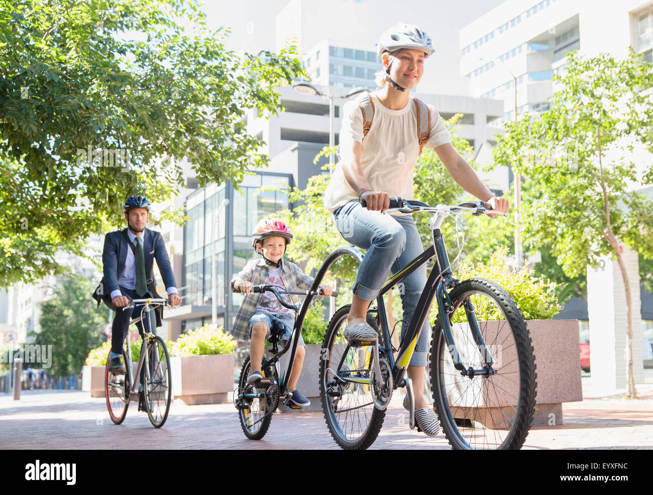 Mutter und Sohn in Helme mit Tandem Fahrrad im Stadtpark Stockfoto