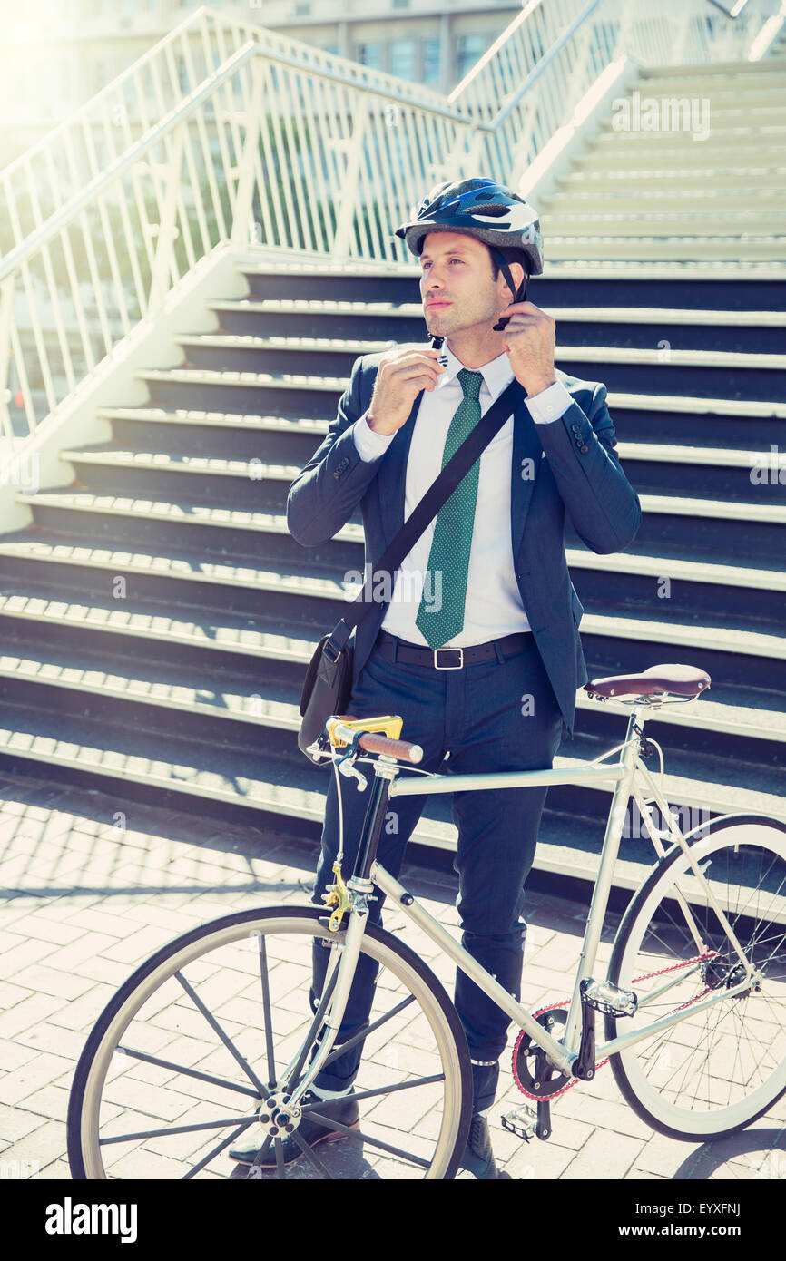 Geschäftsmann im Anzug mit Fahrrad Helm in der Nähe von urban Treppen Befestigung Stockfoto