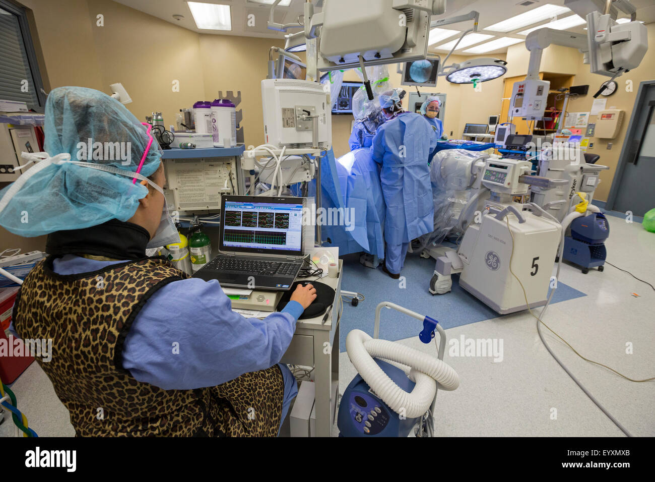 Englewood, Colorado - ein Neurophysiologe überwacht den Zustand der Spinalnerven des Patienten während der Operation der Lendenwirbelsäule. Stockfoto