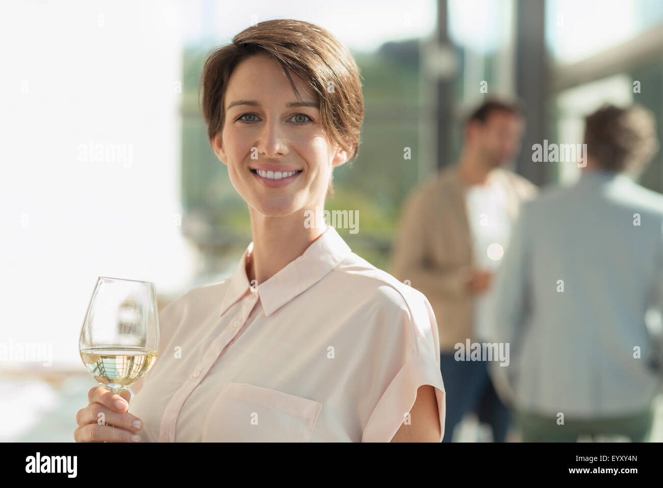 Porträt lächelnde Frau trinken Weißwein Stockfoto