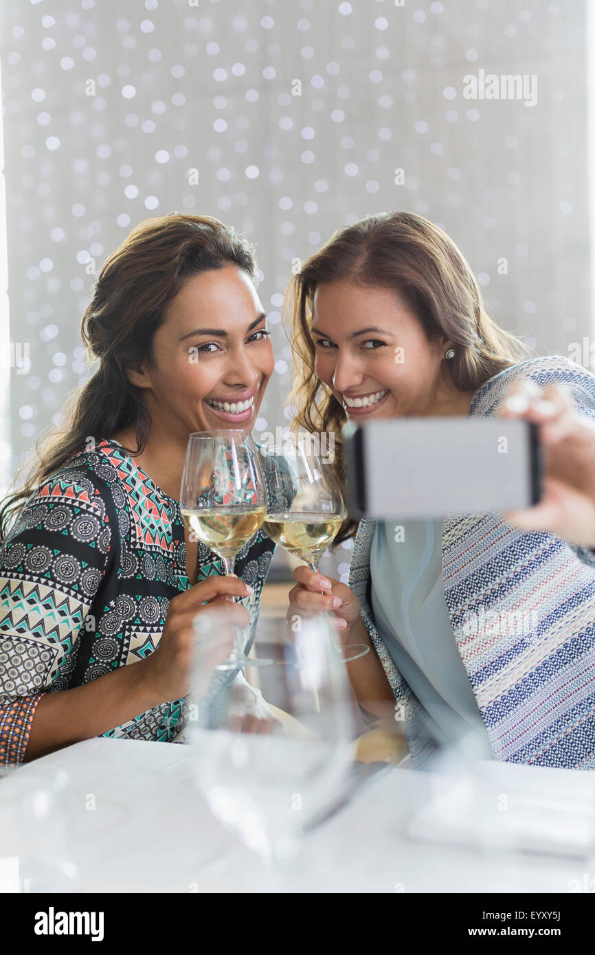 Frauen mit weißen Wein nehmen Selfie mit Kamera-Handy im restaurant Stockfoto