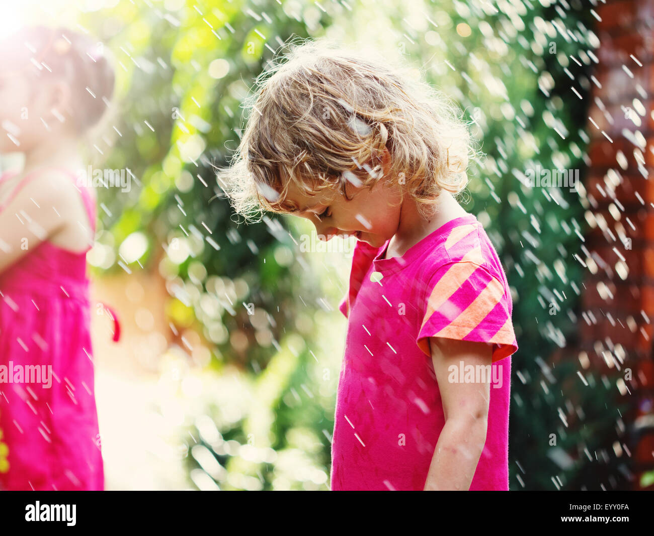 Glücklich niedliche kleine Mädchen im Regen stehen. Porträt hautnah. Stockfoto
