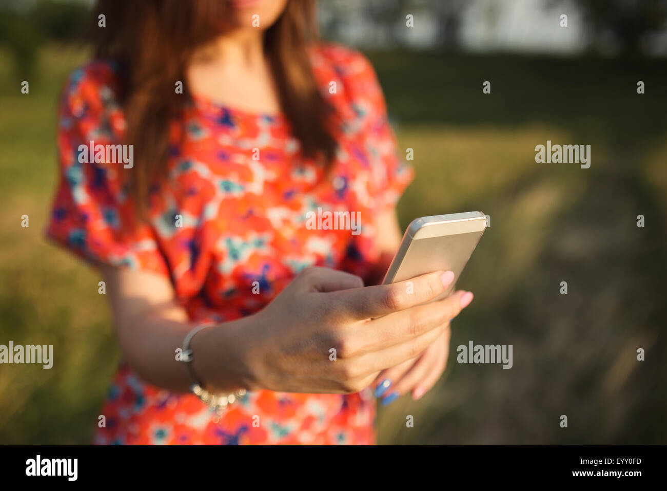 Nahaufnahme der junge Frau im roten Kleid mit mobilen Smartphone Sommer im freien Stockfoto