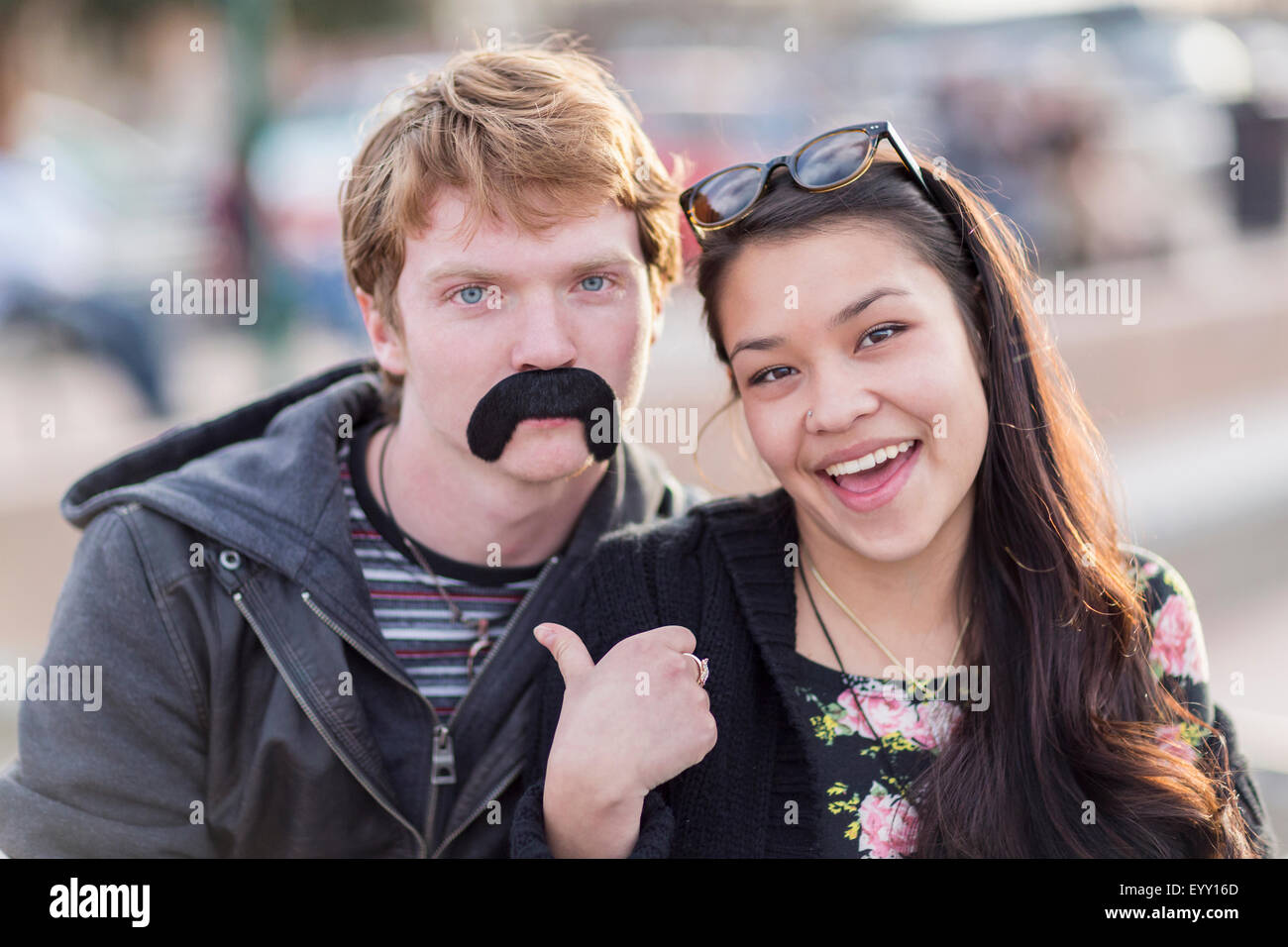 Teenager-Paar spielt mit falschen Schnurrbart Stockfoto