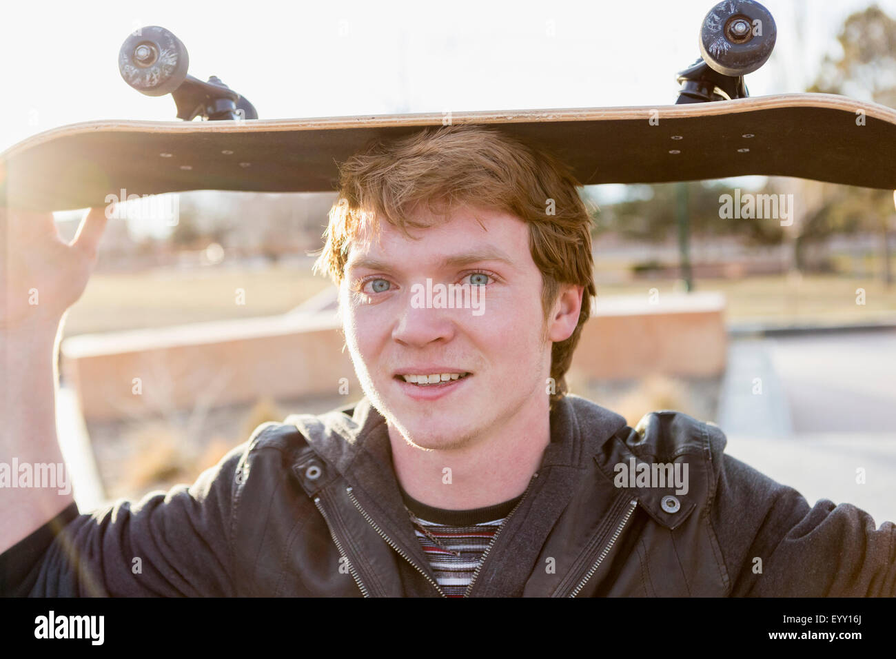 Kaukasische Teenager Ausgleich Skateboard auf Kopf Stockfoto