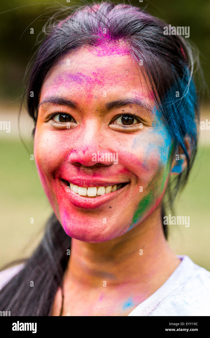 Asiatische Frau lächelnd in Pigmentpulver abgedeckt Stockfoto