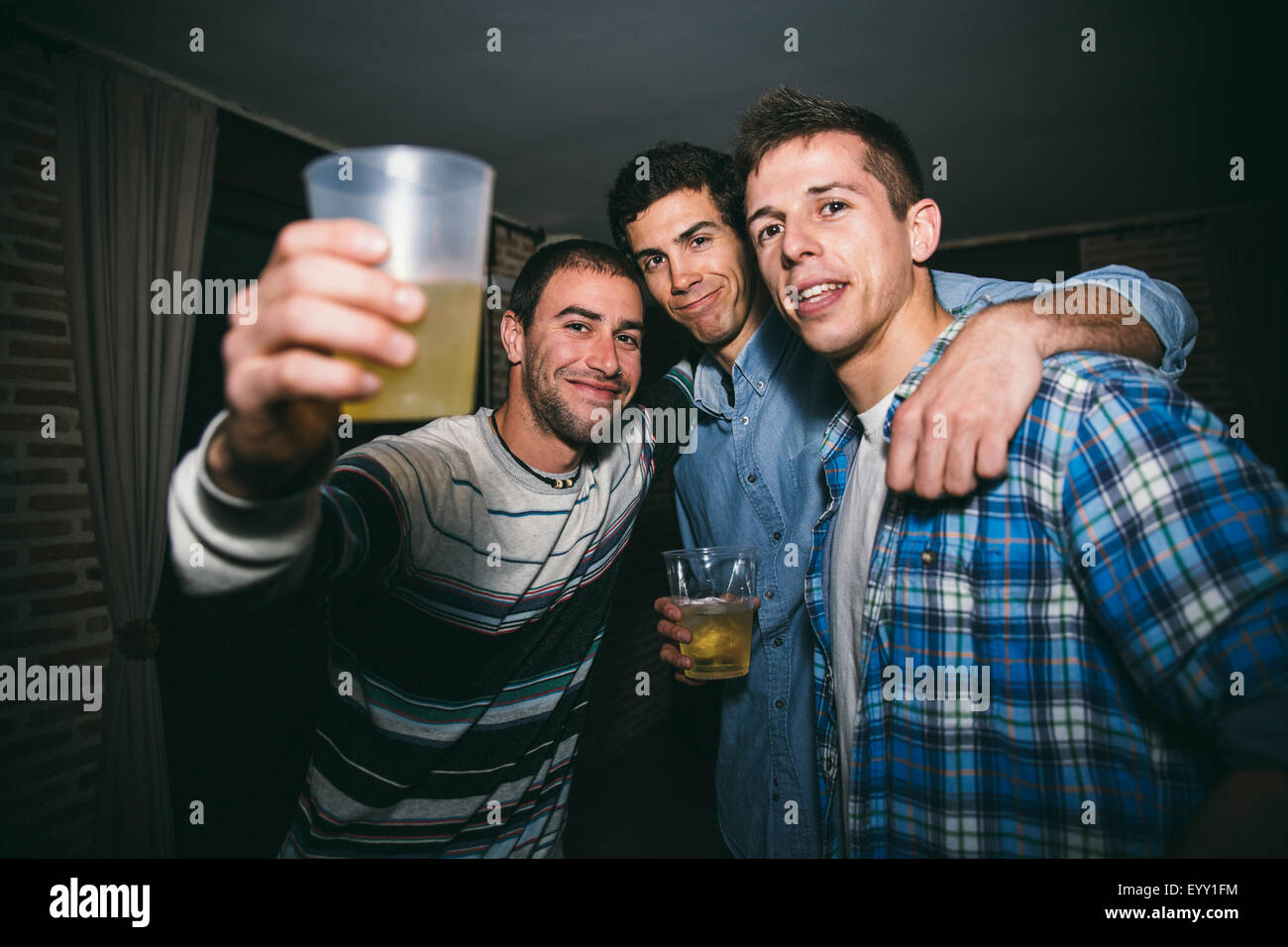 Lächelnde Männer trinken in Nachtclub Stockfoto