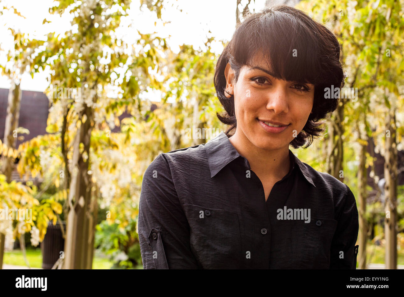 Hispanic Frau lächelnd in park Stockfoto