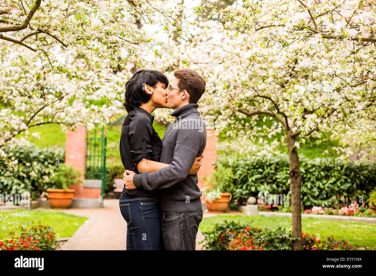 Paar küssen unter blühenden Bäumen im park Stockfoto