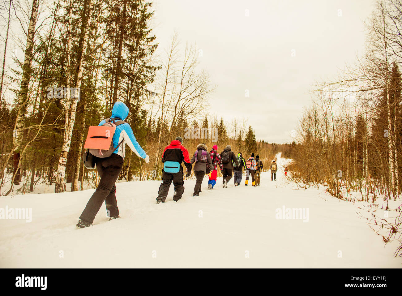 Kaukasische Wanderer zu Fuß in einer Reihe auf verschneiten Pfad Stockfoto