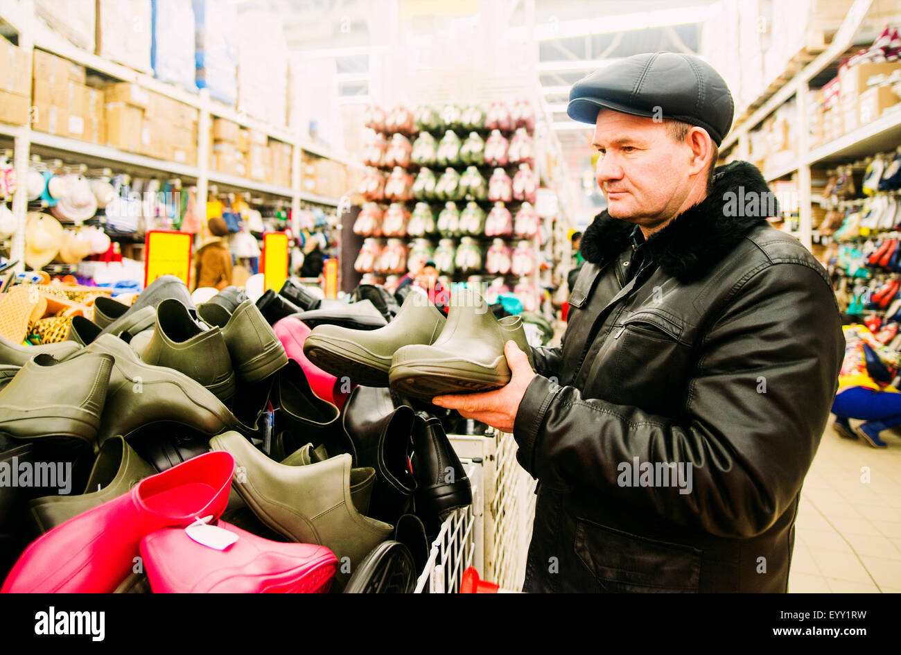 Kaukasischen Mann für Regenstiefel im Store einkaufen Stockfoto