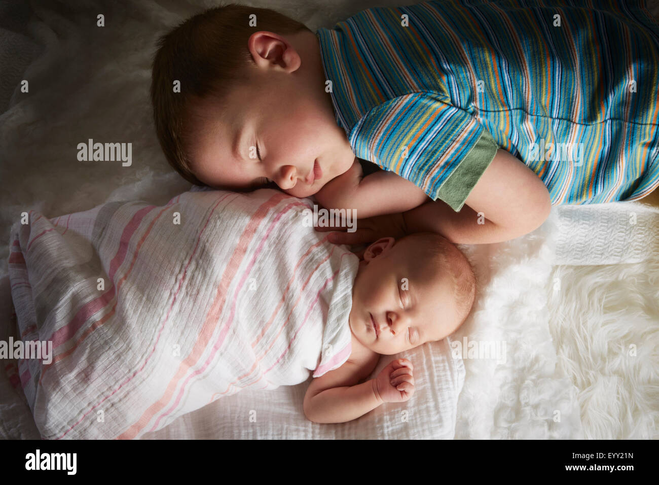 Junge Nickerchen mit Neugeborenen Geschwister auf Bett Stockfoto