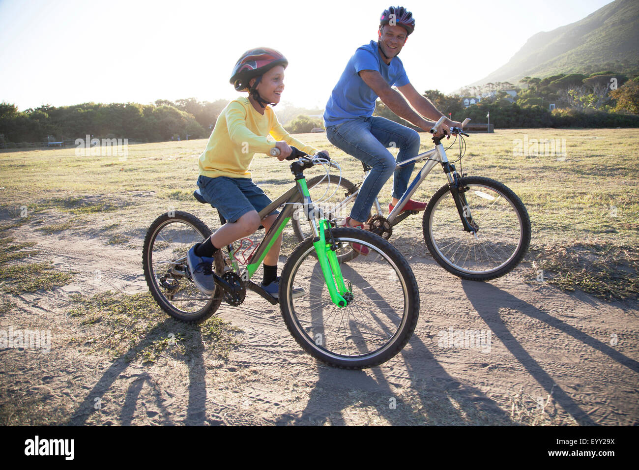 Kaukasische Vater und Sohn auf Fahrrädern auf Feldweg Stockfoto