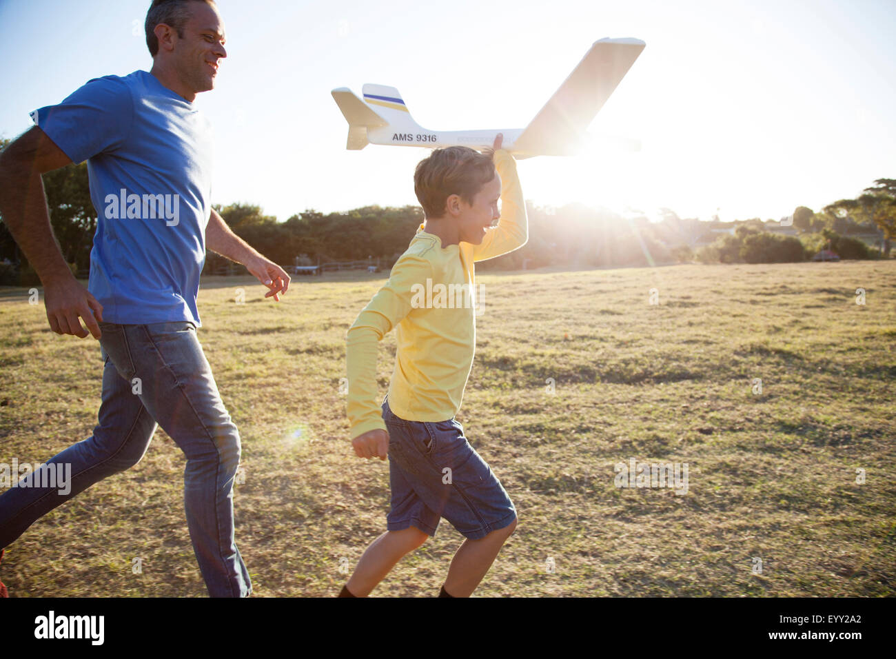 Kaukasische Vater und Sohn fliegen Modellflugzeug im Feld Stockfoto