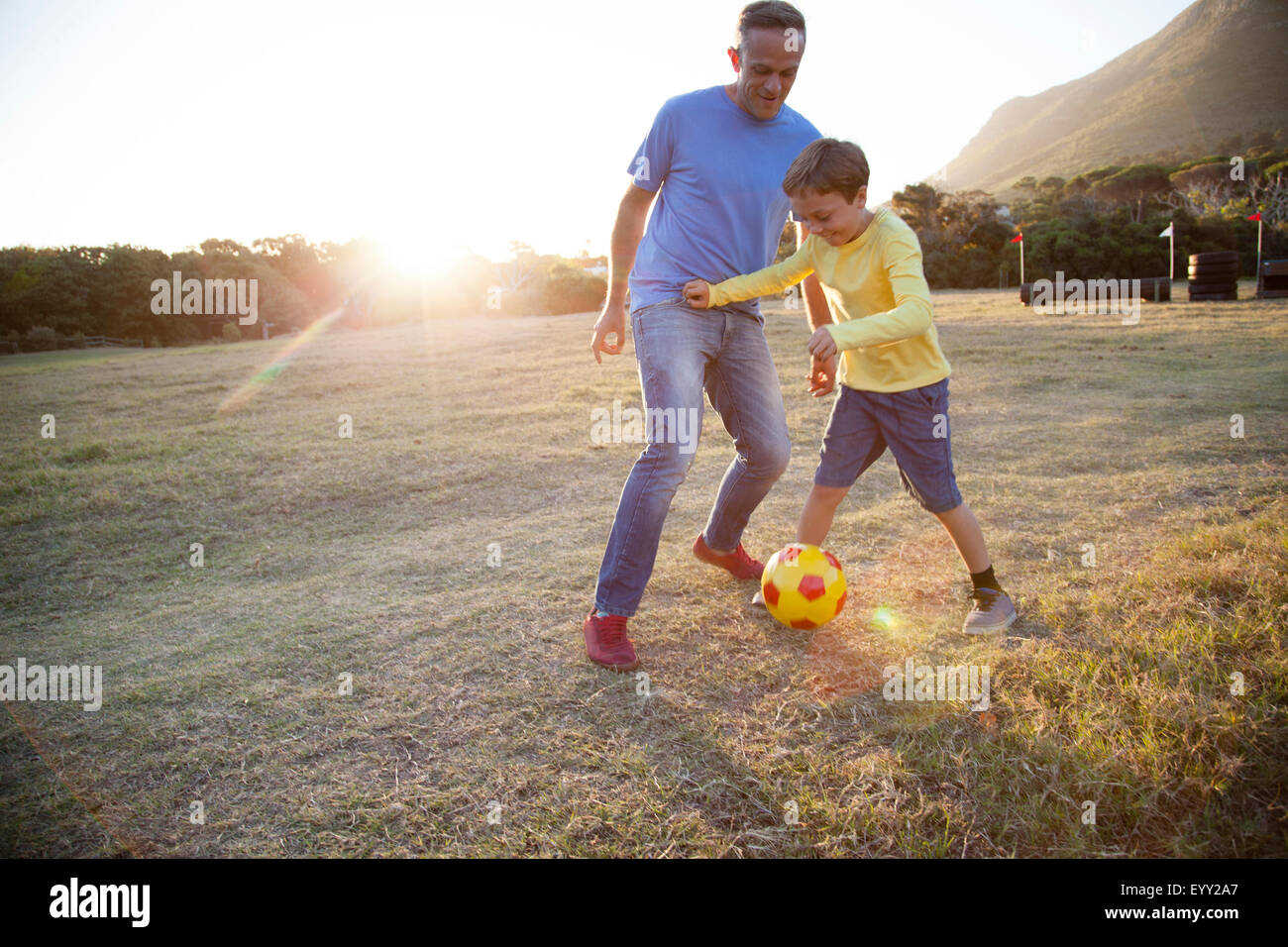 Kaukasische Vater und Sohn spielt Fußball im Feld Stockfoto