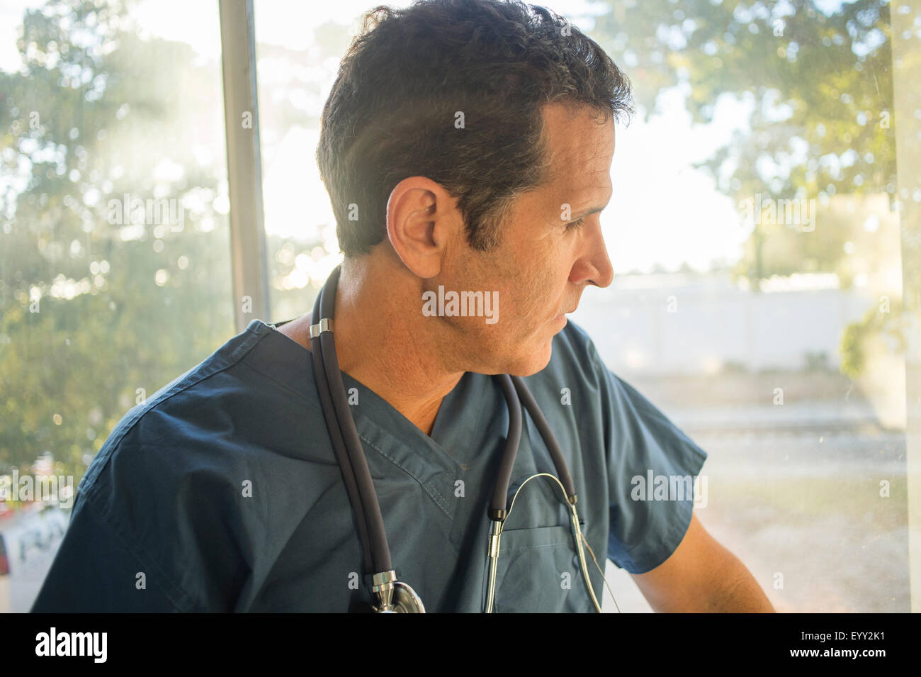 Hispanische Arzt suchen Fenster Stockfoto