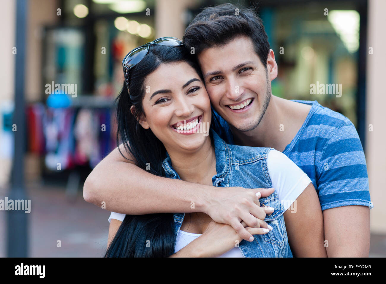 Hispanische paar umarmt auf Stadt Bürgersteig Stockfoto