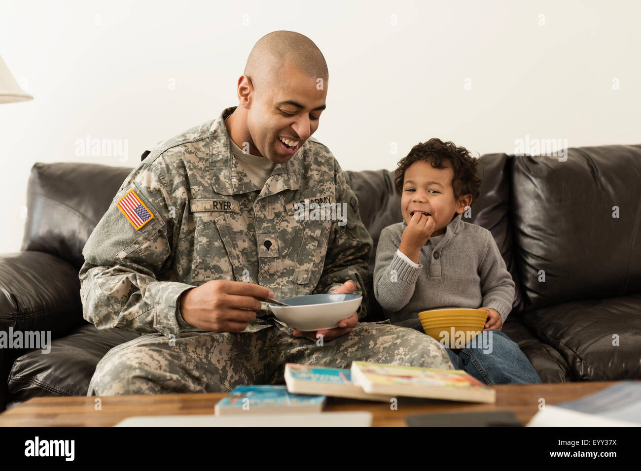 Gemischte Rassen Soldat Vater und Sohn von Schalen auf sofa Stockfoto