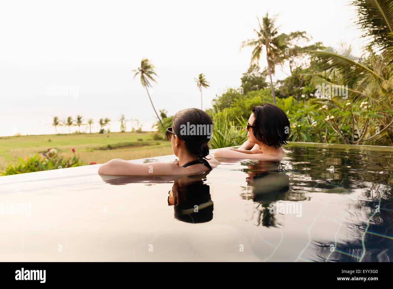 Frauen, die malerische Aussicht im Infinity-pool Stockfoto