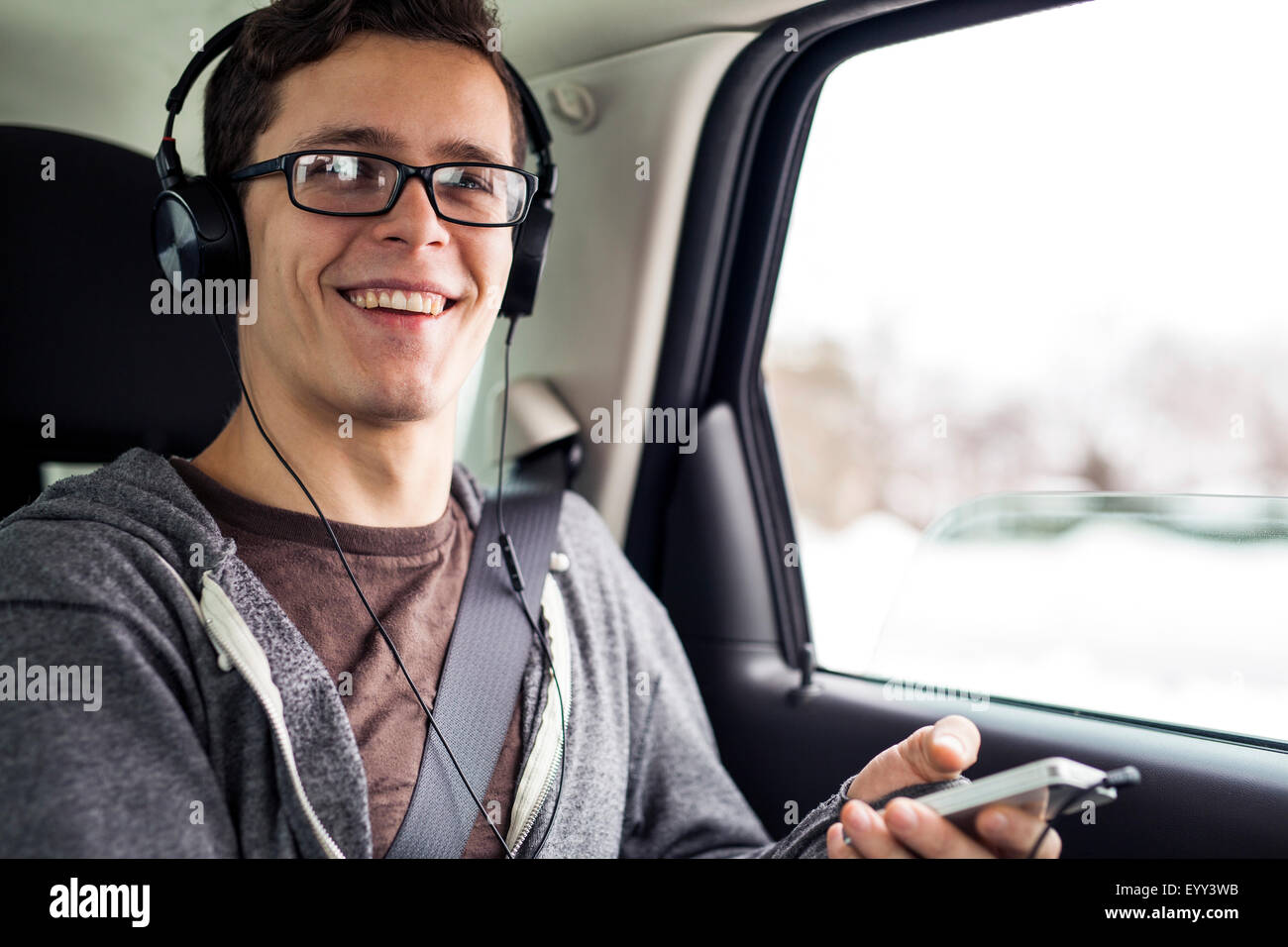 Kaukasischen Mann anhören von MP3-Player im Auto Stockfoto