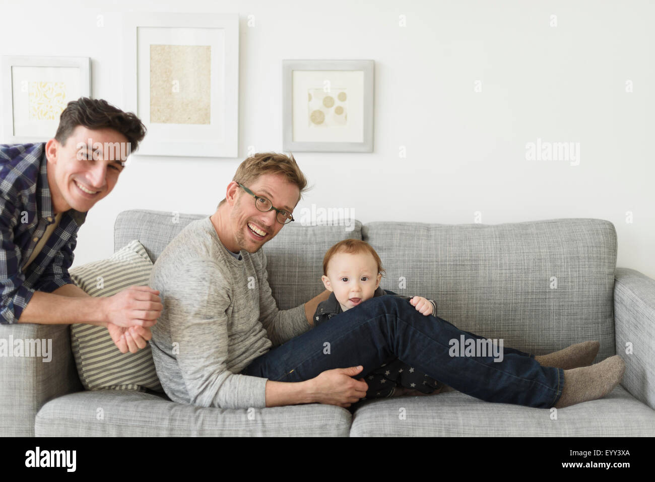 Kaukasische Schwule Väter und Baby entspannend auf sofa Stockfoto