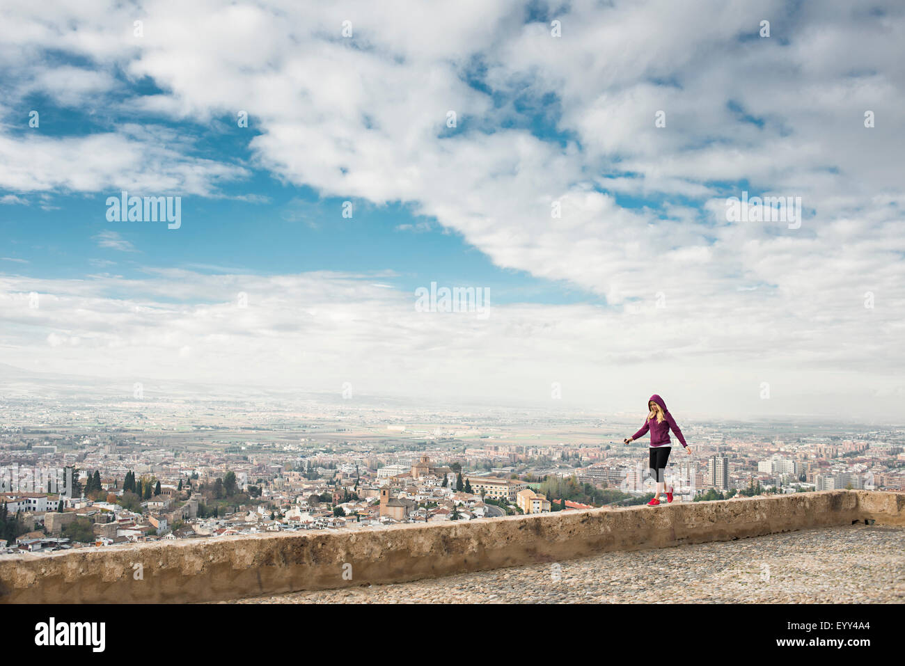 Kaukasische Frau an Wand Blick auf malerische Stadtbild, Granada, Spanien Stockfoto