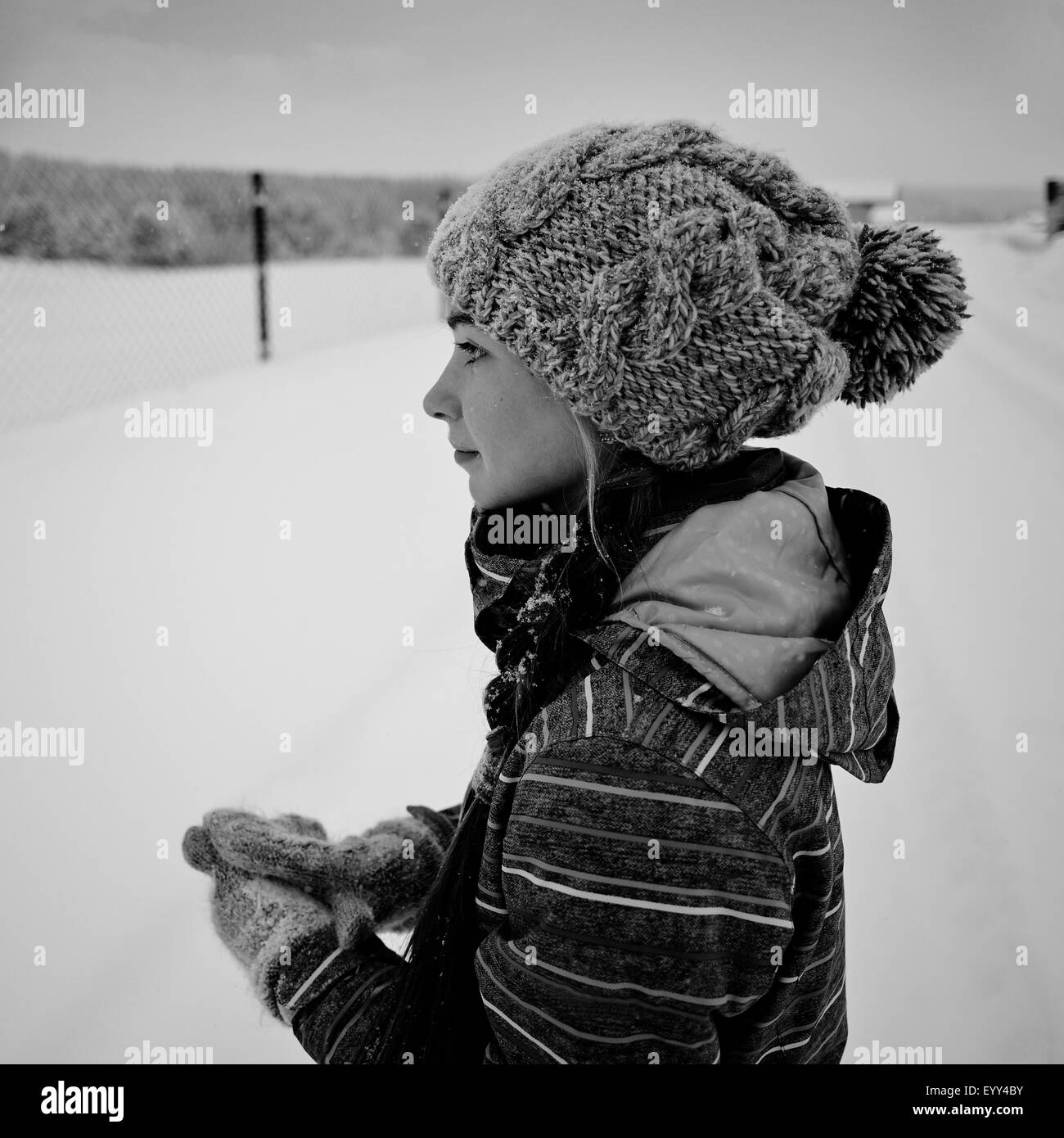 Kaukasische Mädchen tragen stricken, Mütze und Handschuhe im Schnee Stockfoto
