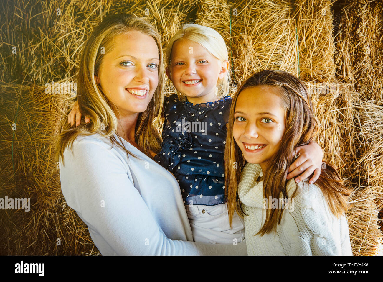 Kaukasische Mutter und Töchter lächelnd in der Nähe von Heuhaufen Stockfoto
