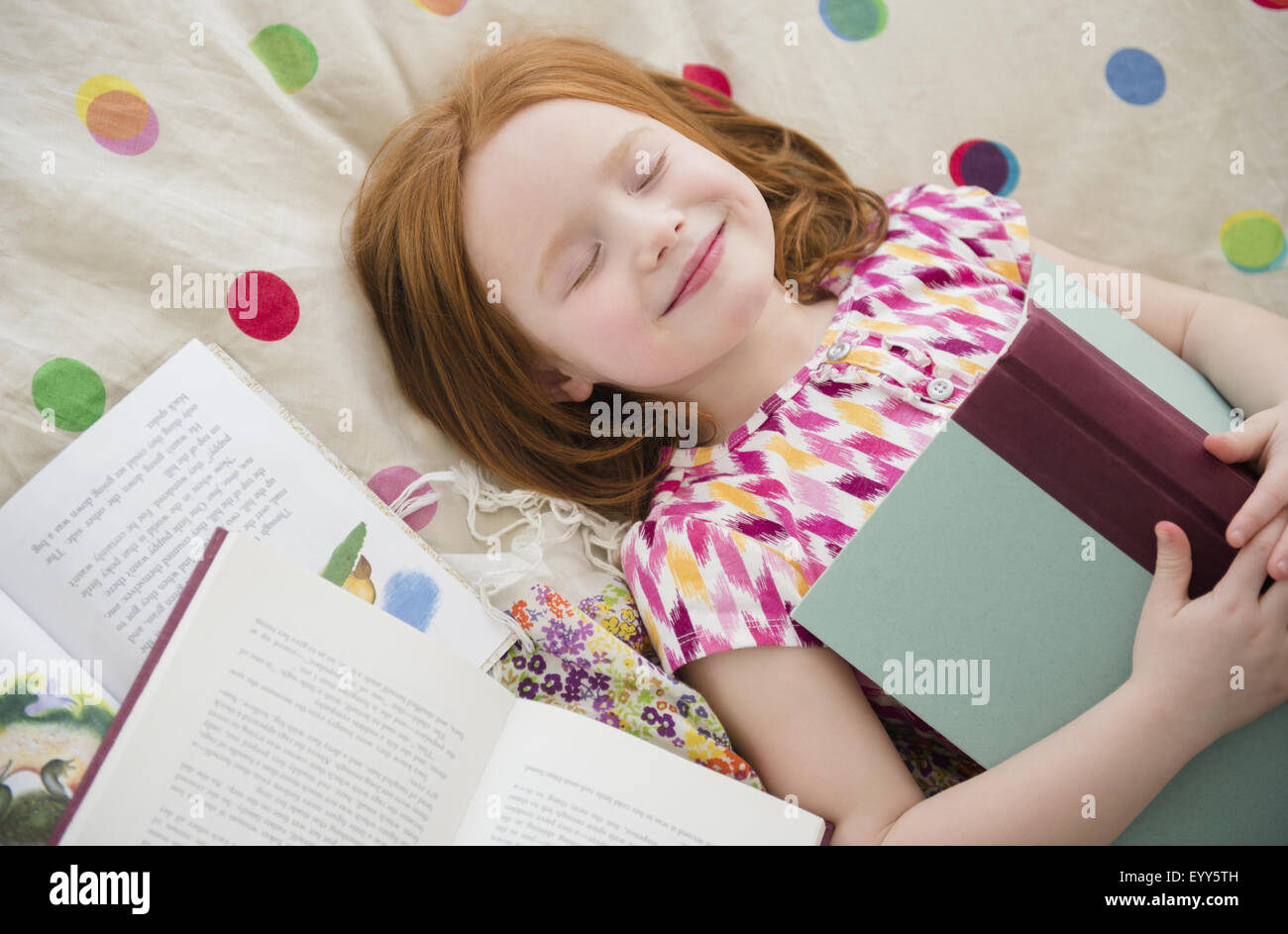 Kaukasische Mädchen lesen Bücher über Bett Stockfoto