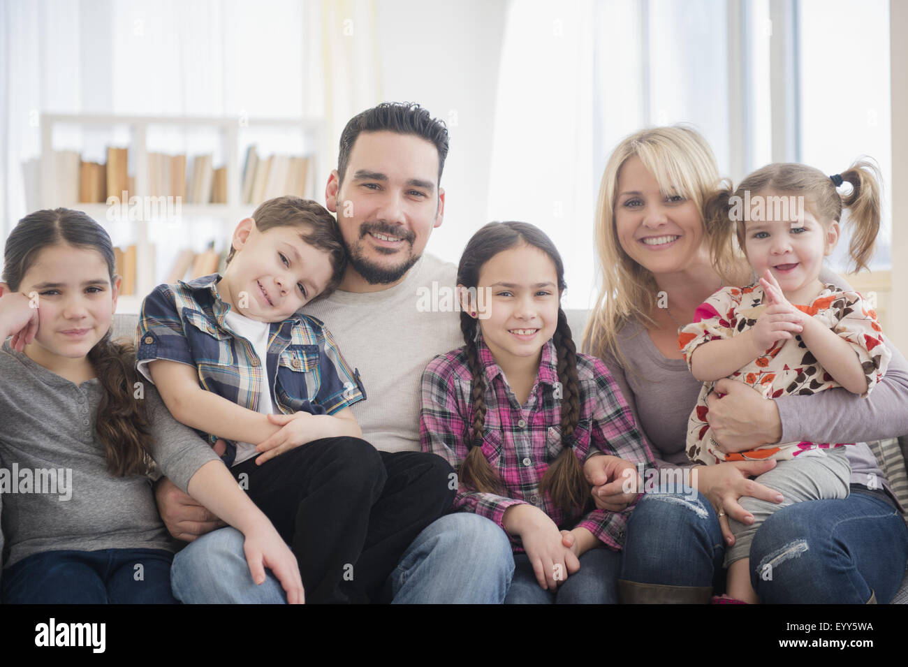 Kaukasische Eltern und Kinder Lächeln im Wohnzimmer Stockfoto