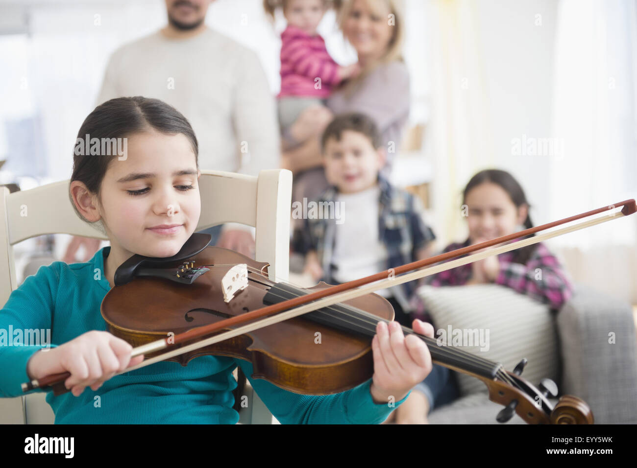 Kaukasische Mädchen spielen Violine im Wohnzimmer Stockfoto