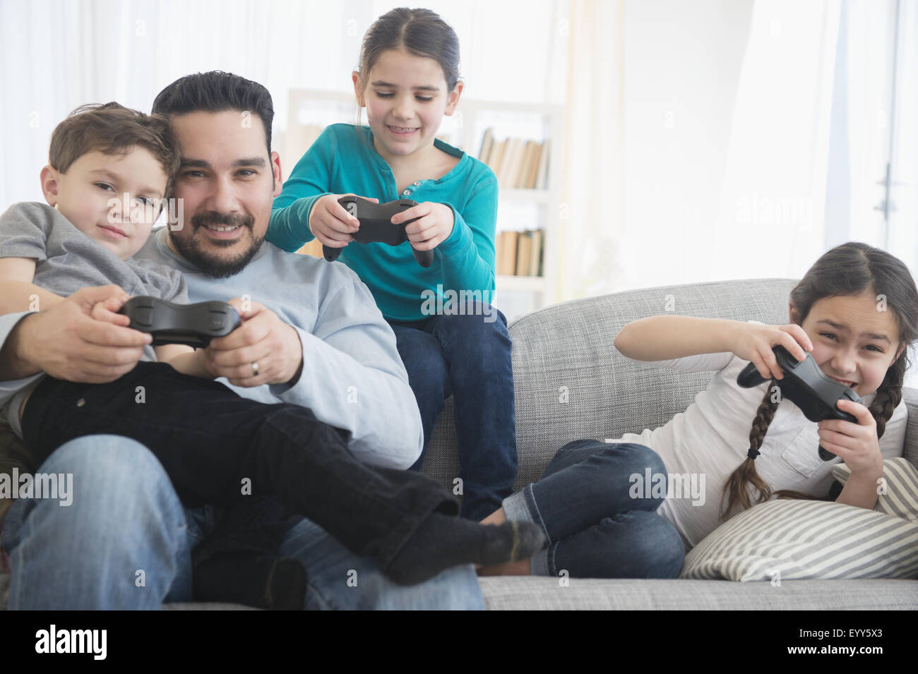 Kaukasische Vater und Kinder spielen von Videospielen auf sofa Stockfoto