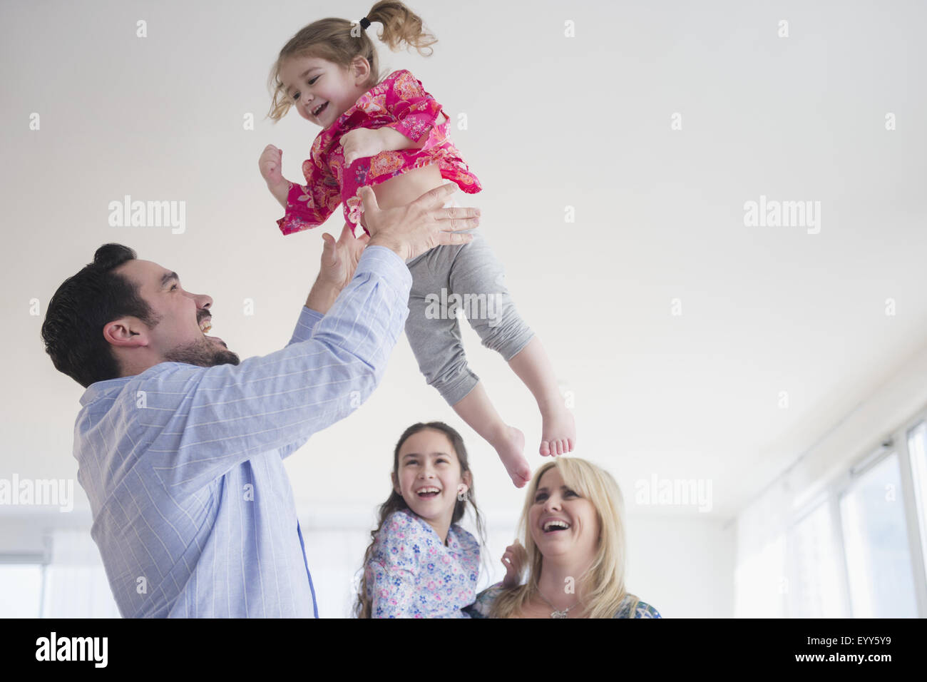 Kaukasische Vater wirft Tochter in Luft Stockfoto