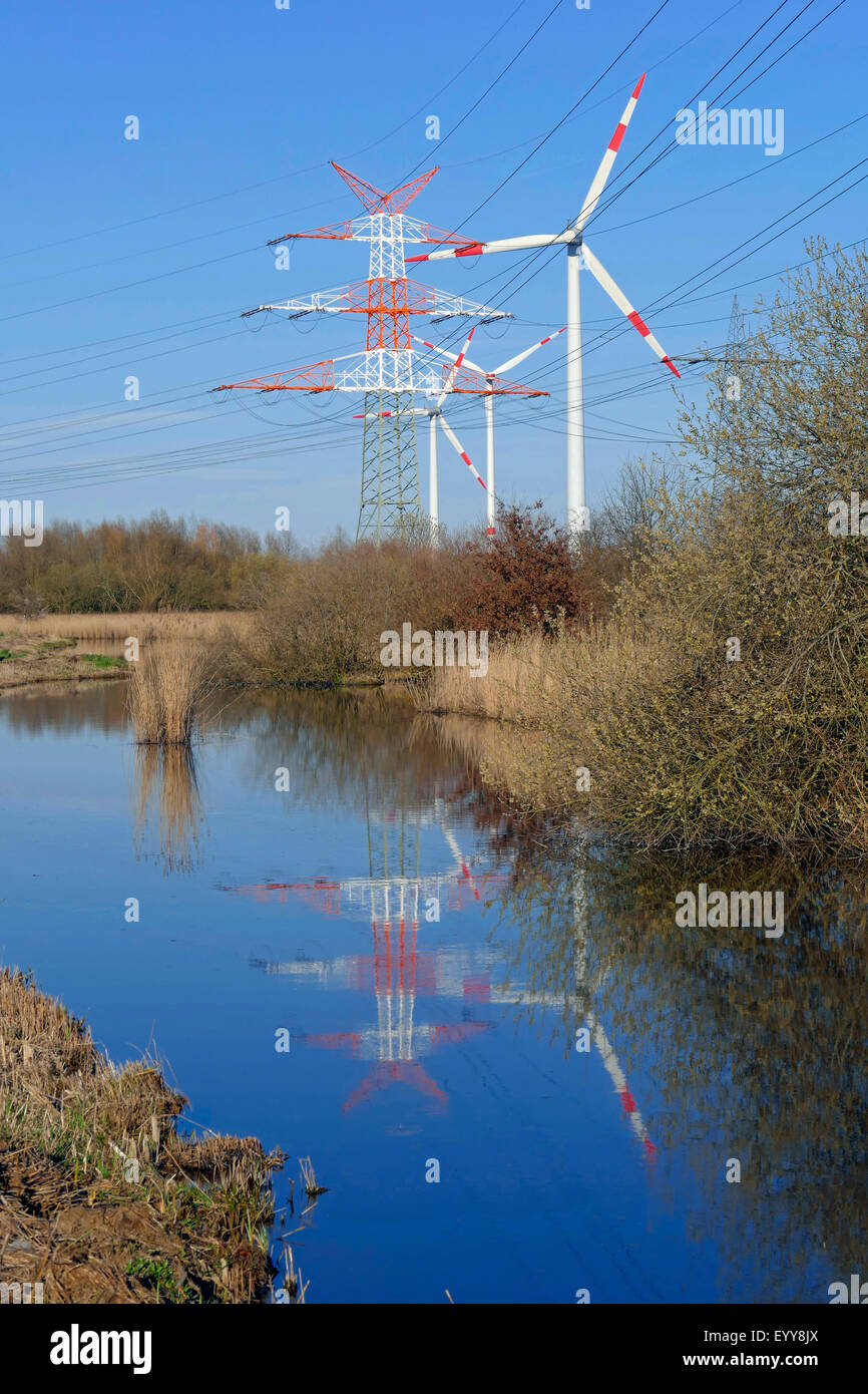 Strommasten und wind Räder Spiegelung in einem Graben, Deutschland, NSG Werderland, Bremen Stockfoto