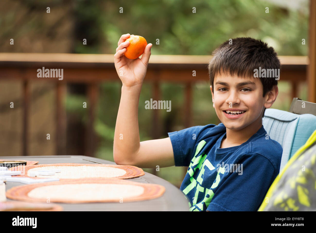 Gemischte Rassen junge Essen Obst am Tisch auf der Veranda Stockfoto