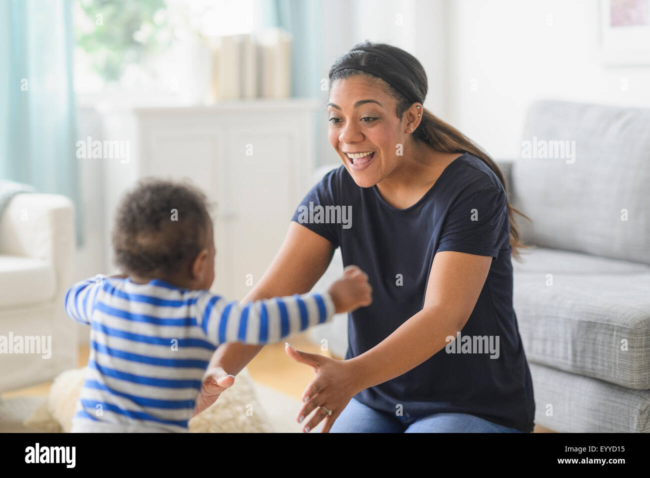 Mischlinge Mutter mit Baby Sohn im Wohnzimmer spielen Stockfoto