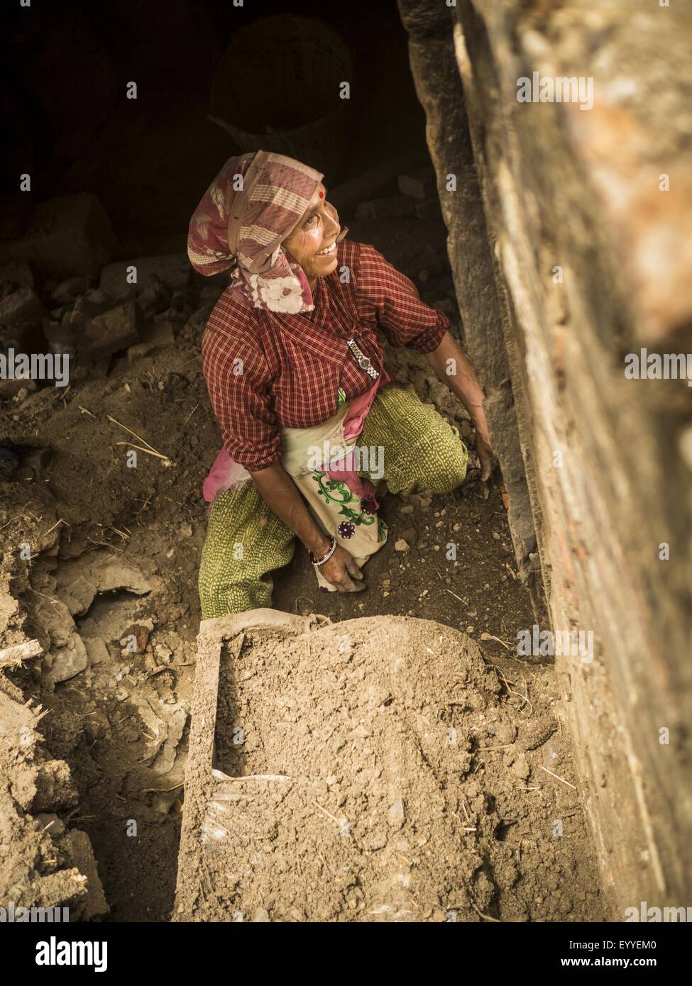 Khokana, zentrale Region, Nepal. 4. August 2015. Eine Frau gräbt sich ihre Familie Reis-Fräsmaschine in ihrem Haus in Khokana, einem Dorf etwa eine Stunde von Kathmandu. Ihr Mann wurde bei dem Erdbeben verletzt und kann nicht funktionieren, so dass sie sich die Fräsmaschine Graben war, die in ihrem Haus gefangen war, als es während des Erdbebens einstürzte. Das Erdbeben in Nepal am 25. April 2015, (auch bekannt als der Gorkha Erdbeben) mehr als 9.000 Menschen getötet und verletzt mehr als 23.000. Es hatte eine Stärke von 7,8. Das Epizentrum lag östlich der Stadtteil Lamjung, und seine Hypozentrum lag in einer Tiefe des Energieverbrauchs Stockfoto