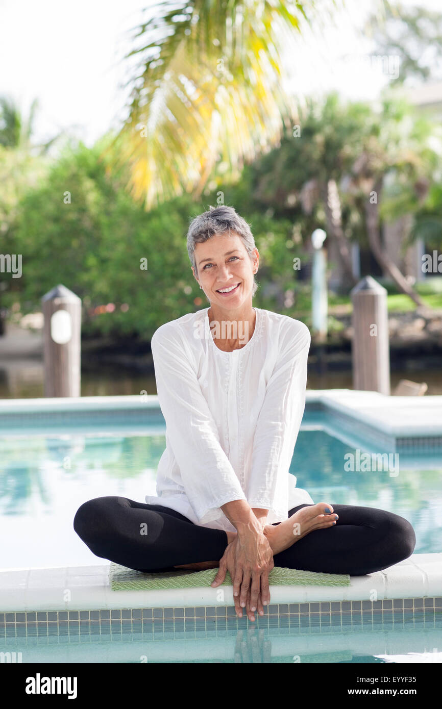 Frau sitzt noch Swimming pool Stockfoto