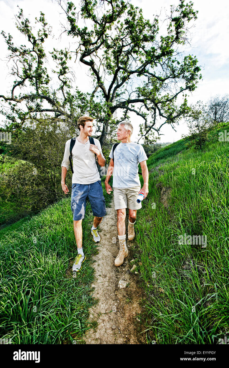 Kaukasische Vater und Sohn gehen auf Feldweg Stockfoto