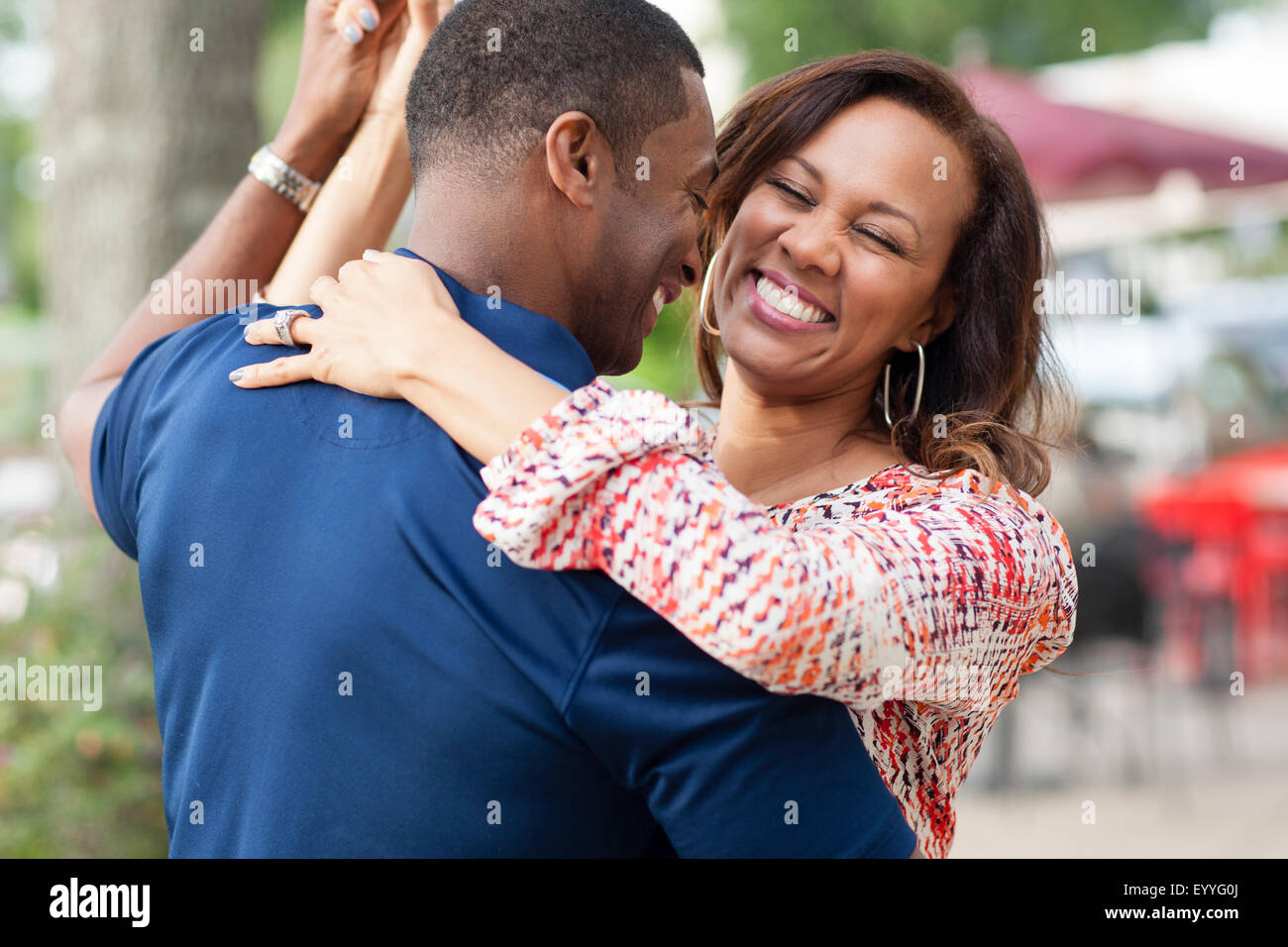 Lächelnde Paare tanzen auf Bürgersteig Stockfoto