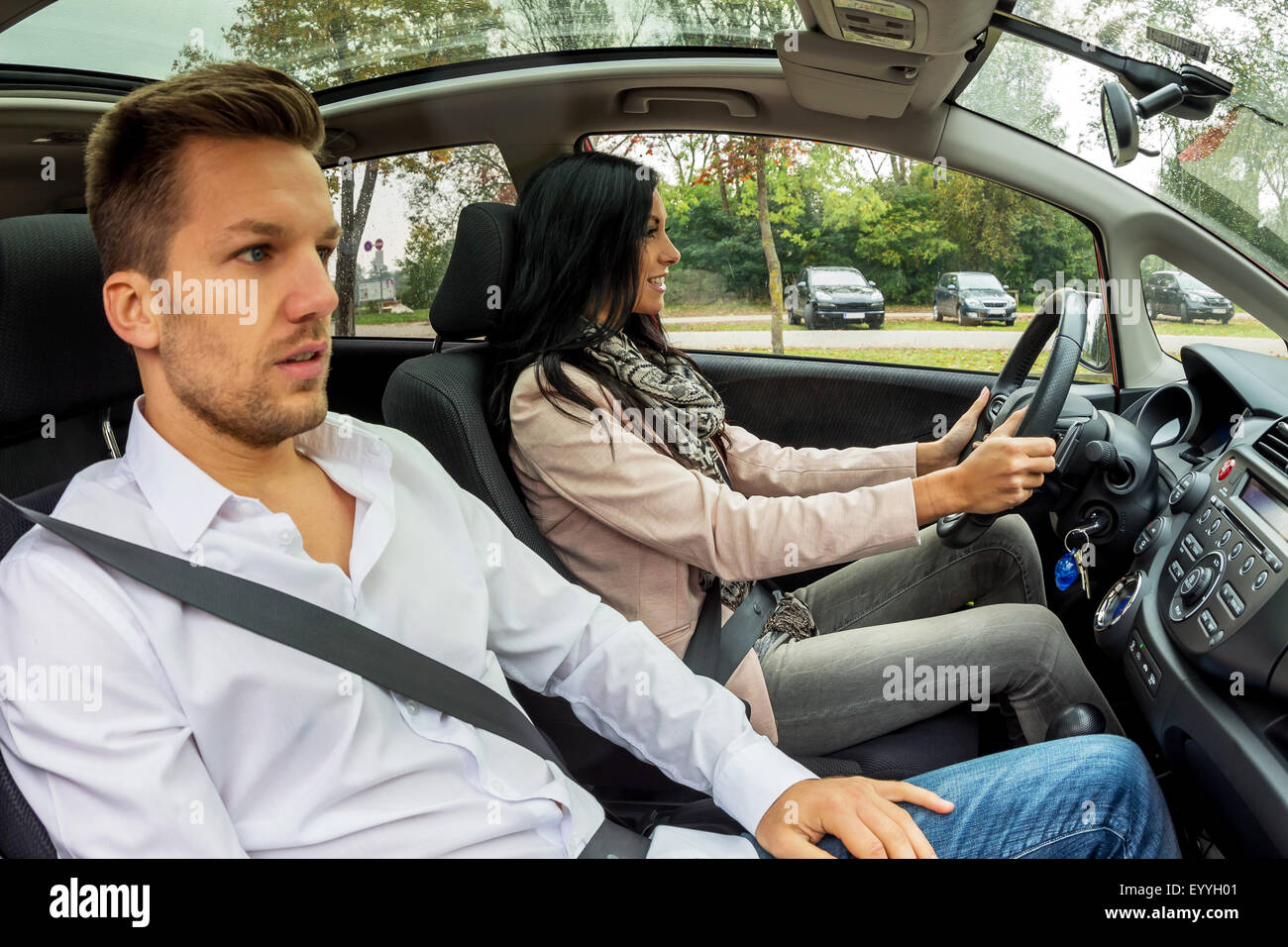 junge Frau fahren Autos mit gestressten Mann als Beifahrer, Österreich Stockfoto