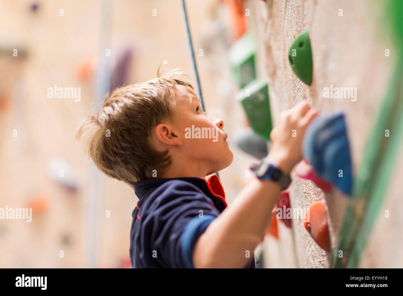 Kaukasische junge Rock Kletterwand im Haus Stockfoto