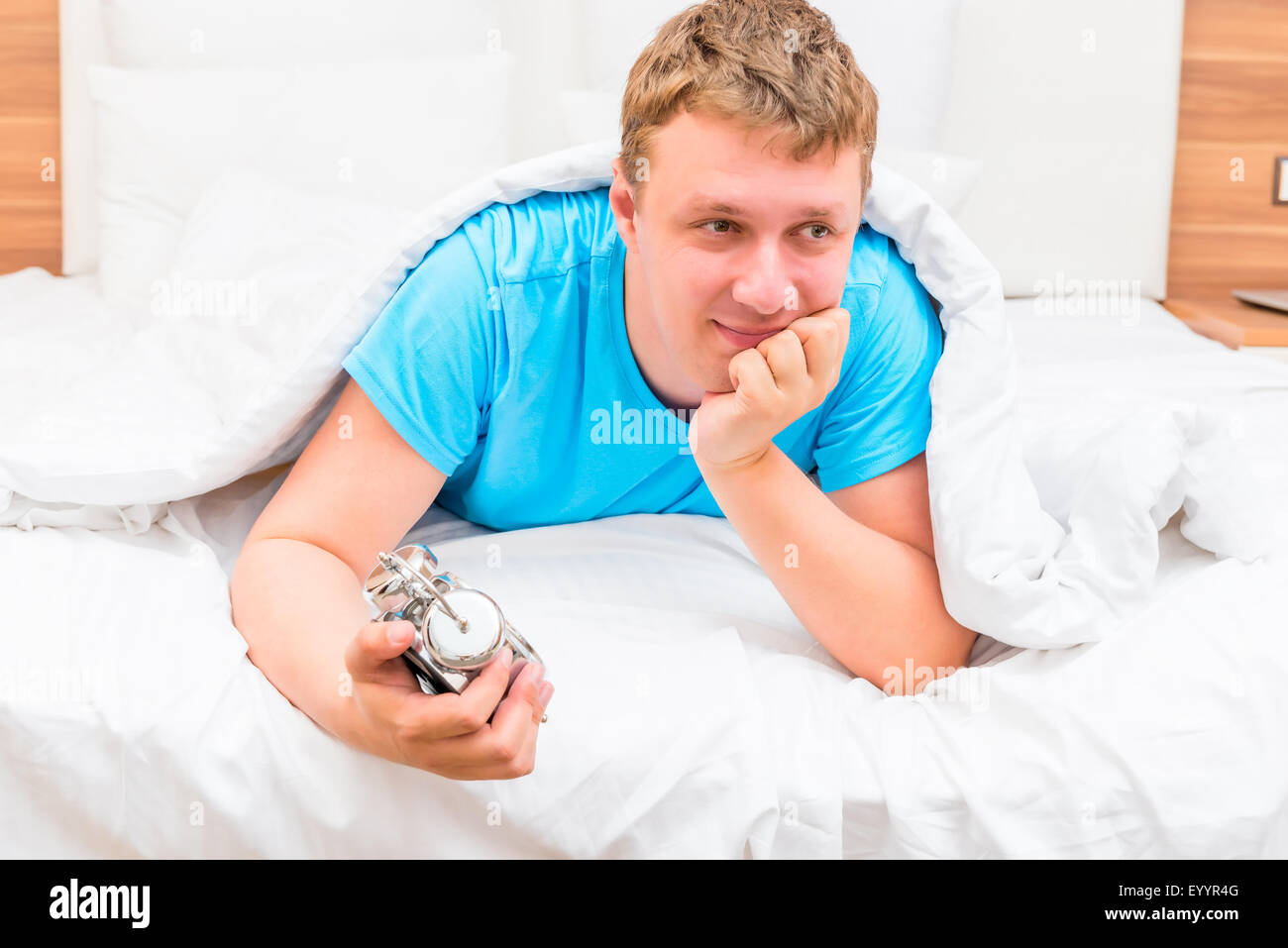 Porträt eines glücklichen Menschen morgens im Bett Stockfoto