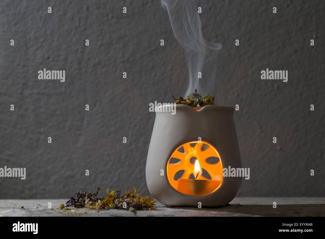 brennende Räucherstäbchen mit Kräutern, Aroma-Lampe Stockfoto