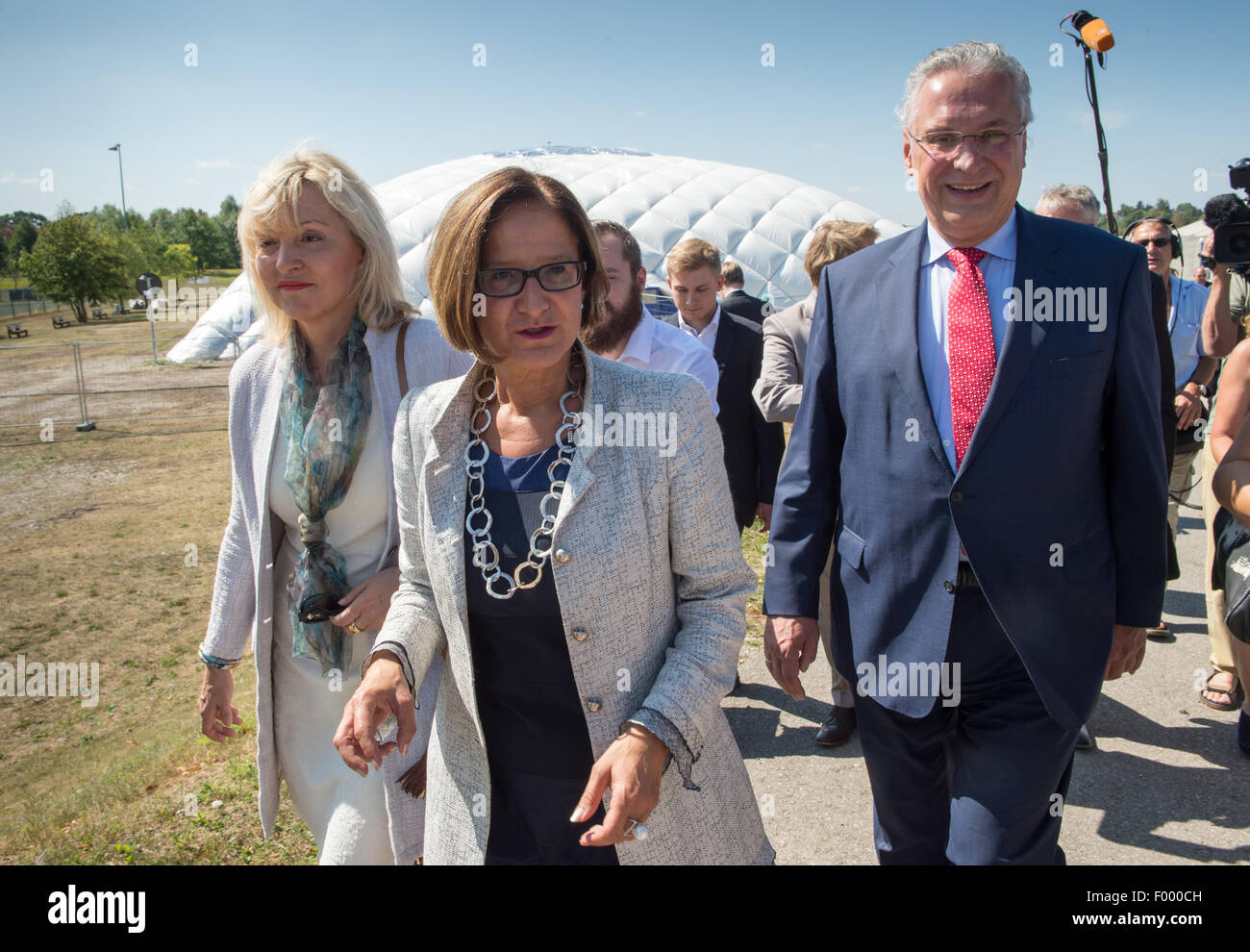 Taufkirchen, Deutschland. 5. August 2015. Joachim Hermann (vorne R-L), Innenminister der deutschen Bundesland Bayern, seinem österreichischen Amtskollegen Johanna Mikl-Leitner, dem Bayerischen Minister für europäische Angelegenheiten Beate Merk besuchen eine Flüchtlings-Unterkunft in Taufkirchen, Deutschland, 5. August 2015. Die Flüchtlinge sind in einem offenen Raum unter einer Traglufthalle untergebracht. Foto: PETER KNEFFEL/Dpa/Alamy Live News Stockfoto