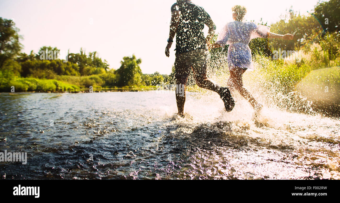 Glückliches Paar laufen im flachen Wasser. Im Sommer. Stockfoto