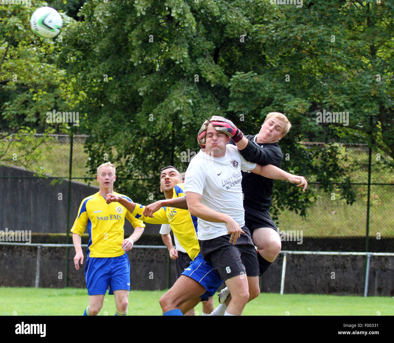 Torhüter Ball verfehlt und Verteidiger Kopf erwischt. Stockfoto