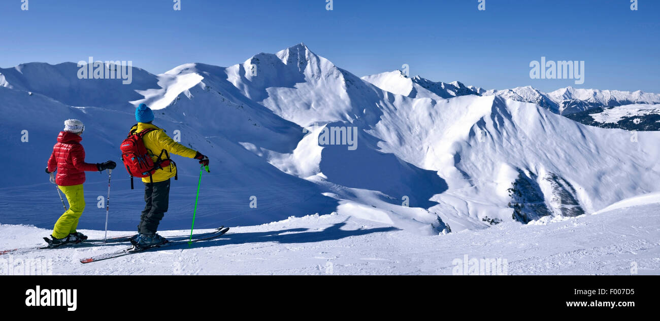 zwei Skifahrer genießen die Aussicht auf schneebedeckte Berglandschaft, Frankreich, Savoyen, La Plagne Stockfoto