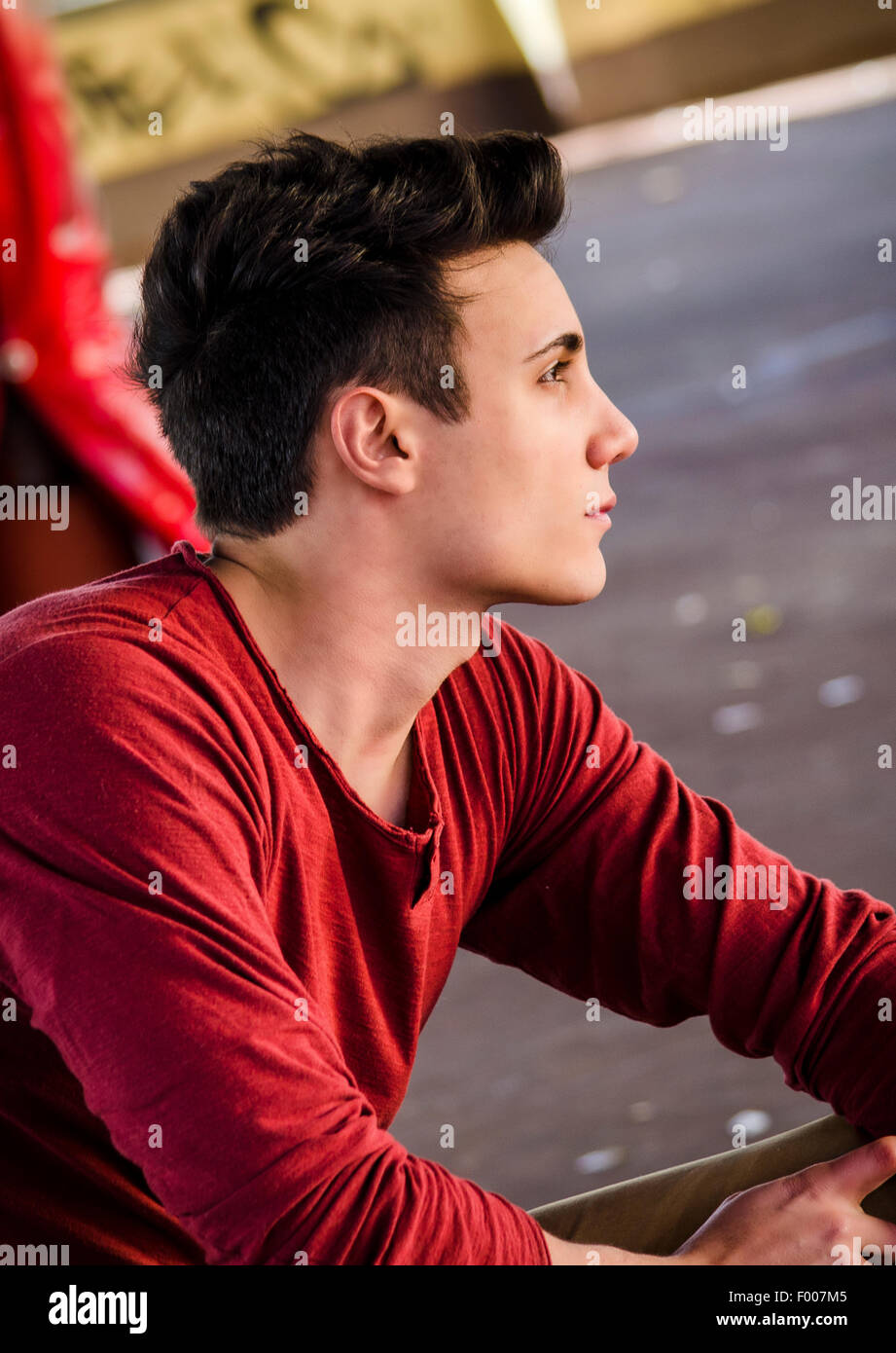 Attraktive junge Mann in urbaner Lage mit Blick auf eine Seite Stockfoto