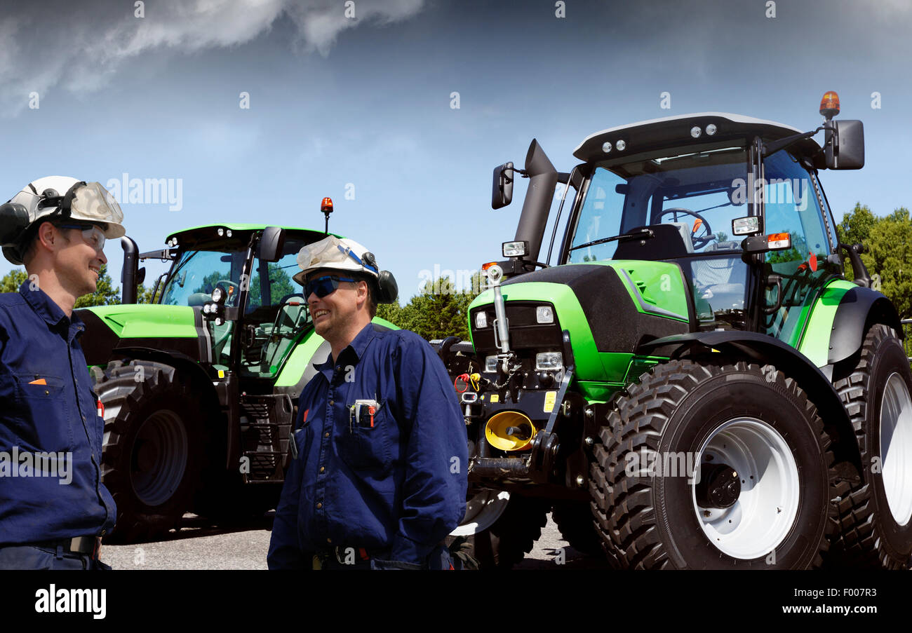 moderne Landwirte mit ihren Traktoren Stockfoto